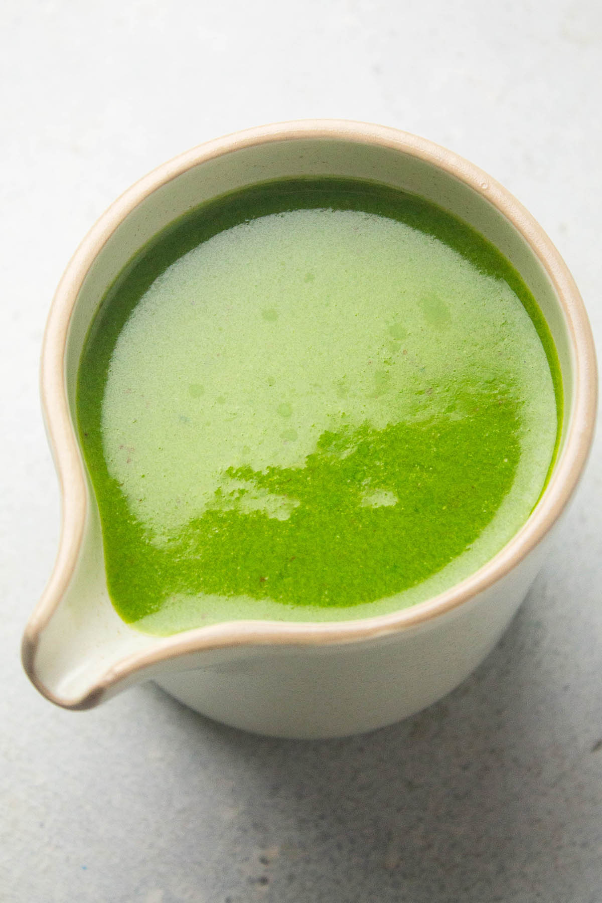 Basil dressing in a carafe.