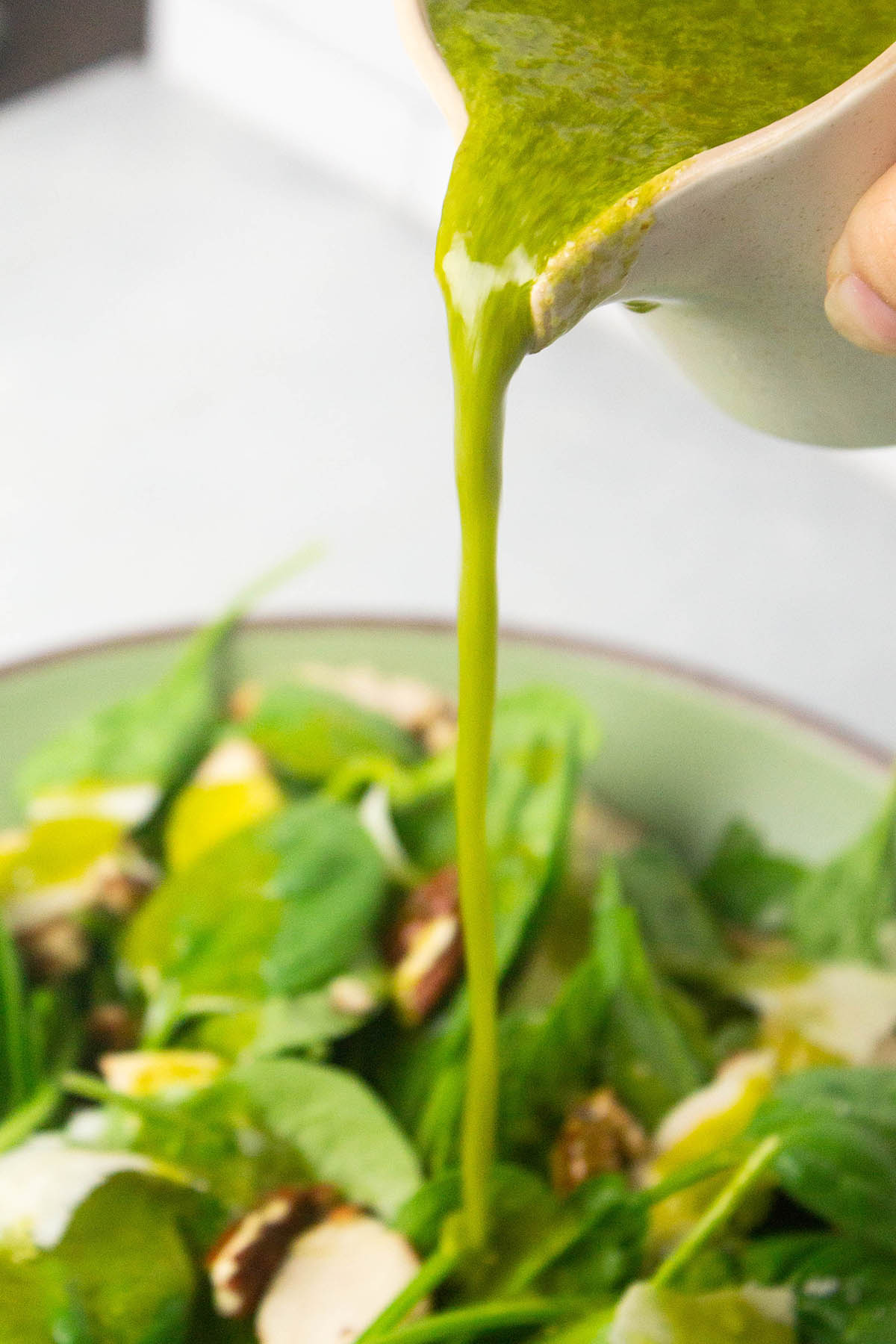Pouring dressing over salad.